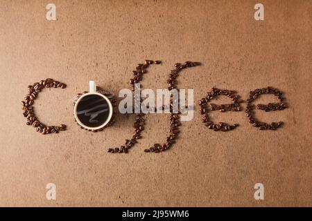 Top view of word coffee made from coffee beans and cup with coffee grains Stock Photo