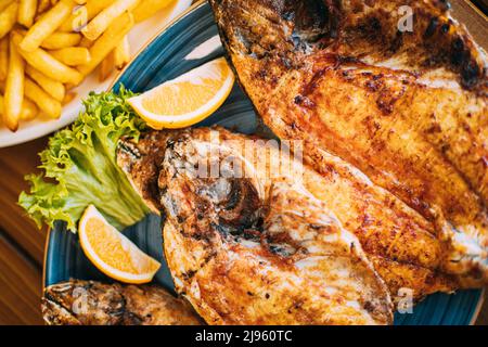 Dish with Gilt-head bream Fish With orange and french fries. Dorada, Dorade, dorado, Dourada fish and chips Stock Photo