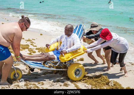 Miami Beach Florida,Sabrina Cohen Adaptive Beach Day,disabled special needs handicapped WaterWheels floating wheelchair,Black man male female woman vo Stock Photo