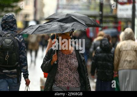 May 15, 2022, Manchester, United Kingdom: A woman tries to hold onto her umbrella as the downpour hits Manchester. The sudden downpour took most people by surprise, many people had to use bags and coats to protect themselves from the rain. (Credit Image: © Jake Lindley/SOPA Images via ZUMA Press Wire) Stock Photo
