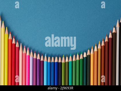 Seamless horizontal pattern Colored pencils arranged in a wave with copy space for note, text, on blue background. Stock Photo