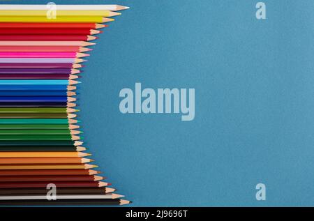 Seamless horizontal pattern Colored pencils arranged in a wave with copy space for note, text, on blue background. Stock Photo