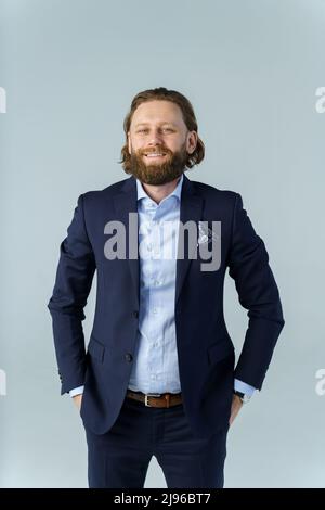 a handsome brutal bearded and long-haired man, a stylish businessman on a white background Stock Photo