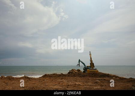 An excavator at a beach landscaping project site in Padang, West Sumatra, Indonesia. Stock Photo