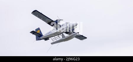 Harbour Air Seaplane leaving Coal Harbour. Cloudy Sky Background. Stock Photo