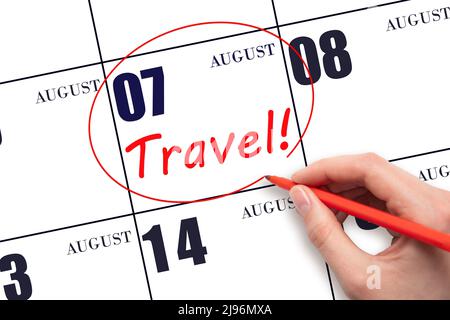 7th day of August. Hand drawing a red circle and writing the text TRAVEL on the calendar date 7 August. Travel planning. Summer month. Day of the year Stock Photo