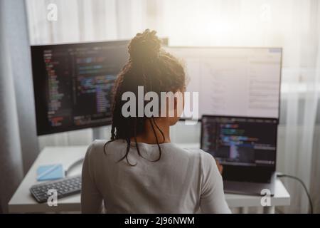 Professional female programmer working on new project on computer at home, back view Stock Photo