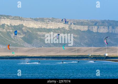 Portland, Dorset, UK.  20th May 2022.  UK Weather:  Kite surfers making the most of the strong breeze at Portland harbour in Dorset on a warm sunny evening.  Picture Credit: Graham Hunt/Alamy Live News Stock Photo