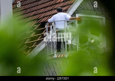Lippstadt, Germany. 21st May, 2022. A worker inspects a damaged roof. One day after the tornado, cleanup work has begun in the city center. Credit: David Inderlied/dpa/Alamy Live News Stock Photo