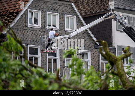 Lippstadt, Germany. 21st May, 2022. A worker inspects a damaged roof. One day after the tornado, cleanup work has begun in the city center. Credit: David Inderlied/dpa/Alamy Live News Stock Photo