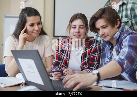College students using laptop, studying together in class Stock Photo