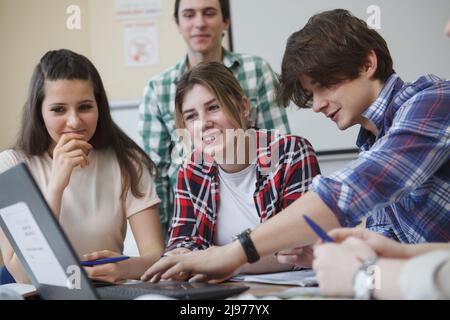 Happy young students smiling and talking while studying Stock Photo