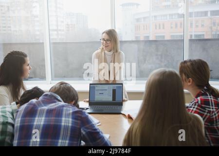 Experienced college teacher talking to her students during seminar Stock Photo
