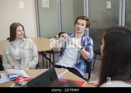 Handsome young male student talking during class at college Stock Photo