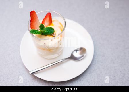 Strawberry parfait with mango sauce decorated with mint leaves Stock Photo