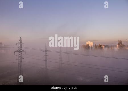 Fog and smog in the city. Power line. Pole wires. Power line top view from the window. Morning in the sleeping area. Clouds sky. Stock Photo