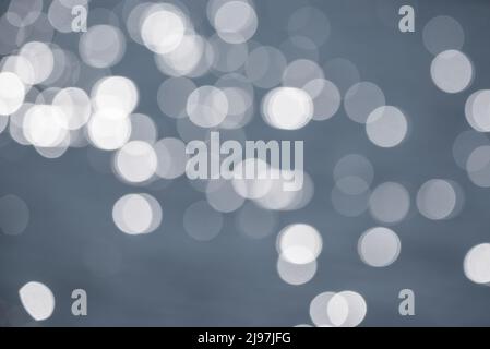 Beautiful blurred bokeh effect image of specular highlights on lake during Summer sunny day Stock Photo