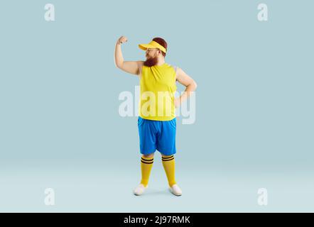 Fat young man proudly flexing his arm and showing muscles after his sports workout Stock Photo