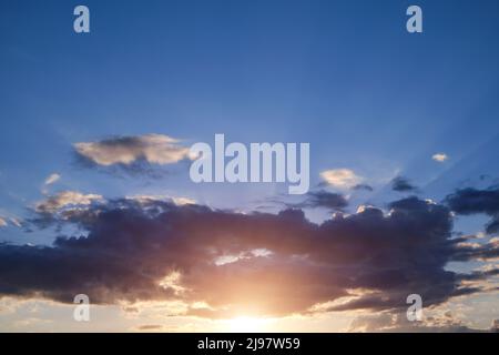 Clouds at sunset with rays sun breaking through them Stock Photo