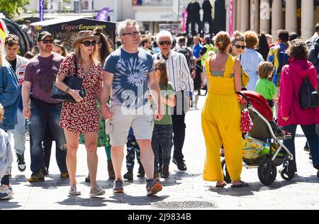 Brighton UK 21st May 2022 - Crowds enjoy the sunshine in Brighton's North Laine area today as the warm weather is forecast to continue over the weekend : Credit Simon Dack / Alamy Live News Stock Photo