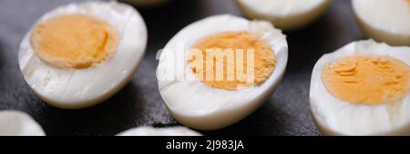 Boiled chicken eggs cut in half on dark background Stock Photo
