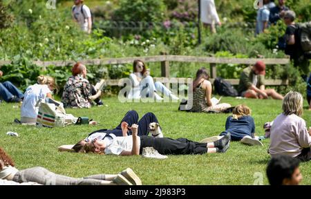 Brighton UK 21st May 2022 - Crowds enjoy the sunshine in Brighton's Royal Pavilion Gardens today as the warm weather is forecast to continue over the weekend : Credit Simon Dack / Alamy Live News Stock Photo