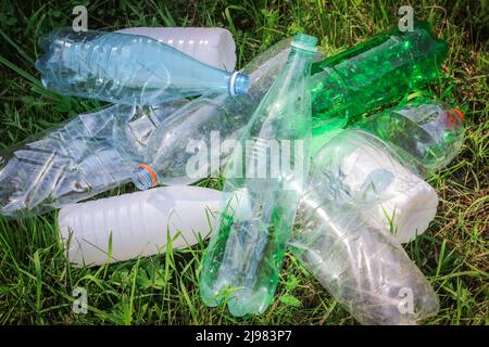 Plastic bottles and bottle caps on grass. Stock Photo