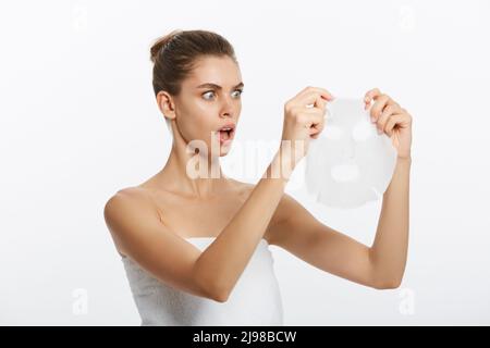 Beautiful woman surprising with facial mask sheet on white background Stock Photo
