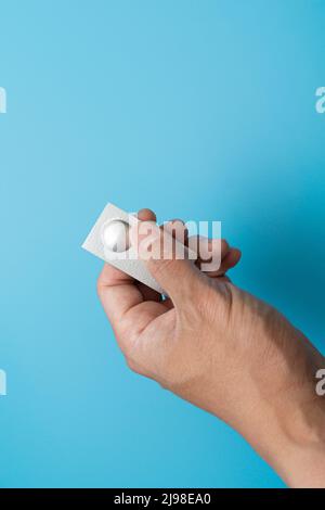 Individually wrapped pills on a blue background Stock Photo