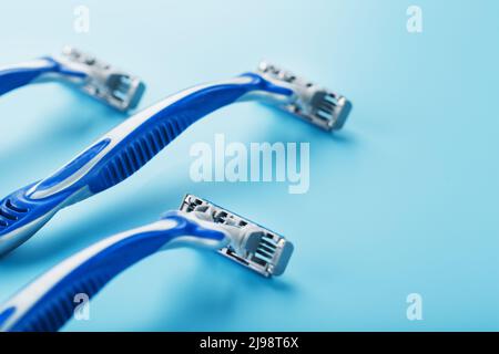 Blue shaving machine with sharp blades on the background of ice cubes close-up. The concept of cleanliness and frosty freshness Stock Photo