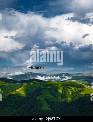 Drone flying in forest with green trees in summer Stock Photo