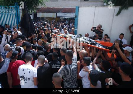 Jenin, Palestine. 12th May, 2022. (EDITOR'S NOTE; Image depicts death)Mourners and gunmen from the Islamic Jihad movement carry the body of the 17-year-old Palestinian, Amjad Al-Fayed, who was shot dead by the Israeli army during a raid on the Jenin refugee camp near the city of Jenin in the occupied West Bank. Credit: SOPA Images Limited/Alamy Live News