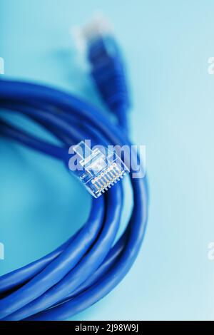 A coil of RJ45 Cat.6 Ethernet Network Internet Cable isolated on a blue background with free space Stock Photo