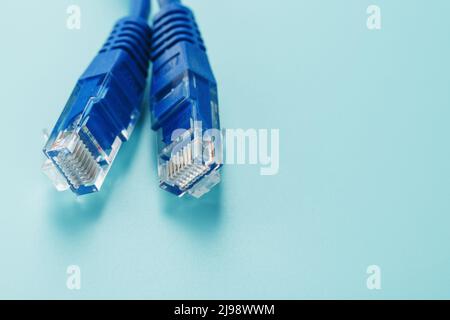 Blue Ethernet Cable Connectors Patch cord cord close-up isolated on a blue background with free space Stock Photo