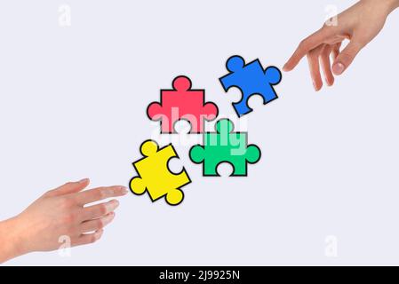 Hands putting colorful puzzle pieces together. Partnership, cooperation, teamwork concept. Finding solution from difficult situation. High quality photo Stock Photo