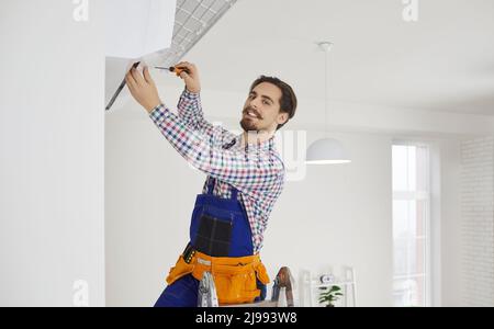 Professional repairman or technician using screwdriver while repairing air conditioner Stock Photo
