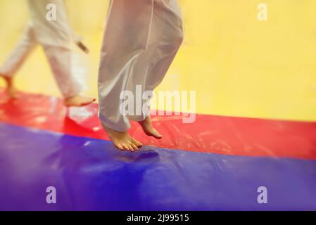 Judo - wrestling, tatami for wrestling, children of sports, legs on a bright colored tatami. Stock Photo