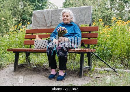 Senior people in Nursing Home, residential facility long-term care services for elderly, older adults. Alone senior woman sitting on bench outdoors Stock Photo