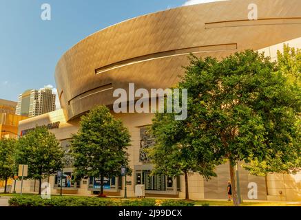 Exterior facade of unique architecture of NASCAR Hall of Fame museum in Charlotte, North Carolina with trees, signal lights, blue sky and clouds. Stock Photo