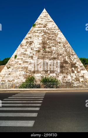 Pyramid of Cestius, Rome, Italy. Ancient Roman tomb in Egyptian style, landmark of Rome at city road. Vertical view of Pyramid of Cestius and street c Stock Photo
