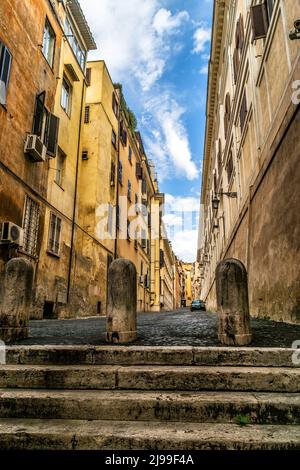 Narrow street with stairs, Rome, Italy. Vertical vintage view of steps and shabby residential buildings in Rome. Antique houses on old street with dea Stock Photo