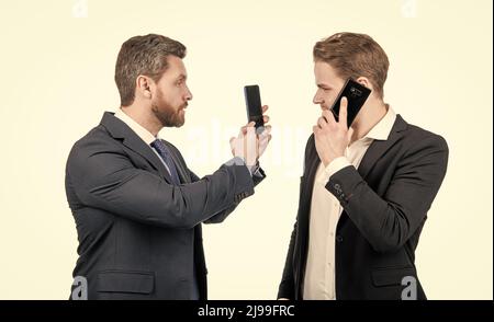 negotiation disagreement of talking man on smartphone and businessman showing phone, argue. Stock Photo