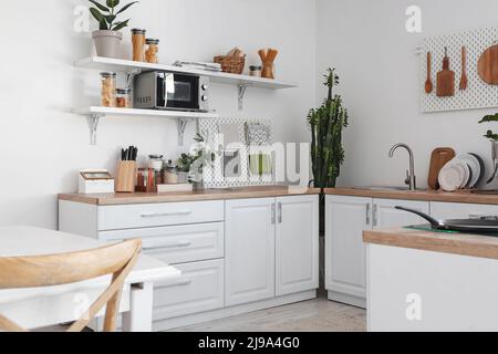 Light kitchen with modern furniture and pegboards near wall Stock Photo