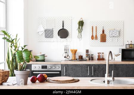 Interior of kitchen with modern counters and pegboards with utensils Stock Photo