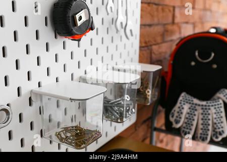 Pegboard with different tools on brick wall, closeup Stock Photo