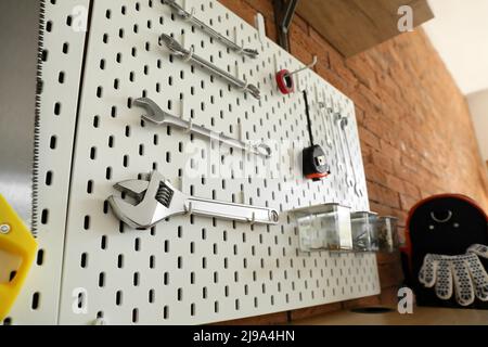Pegboards with tools on brick wall in workshop Stock Photo