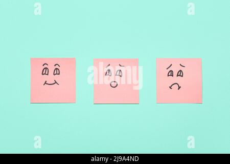 Sticky notes with different smile drawings on color background Stock Photo