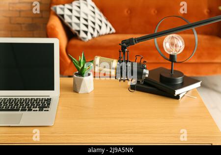 Stand with professional microphone near modern workplace in room Stock Photo