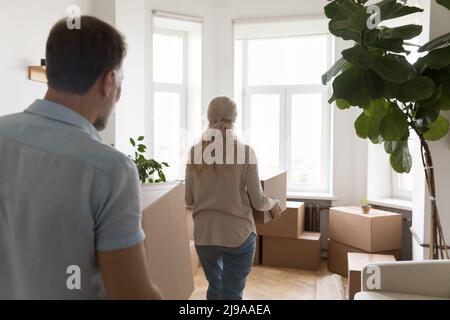 Mature couple moving into new apartment, carrying cardboard boxes Stock Photo