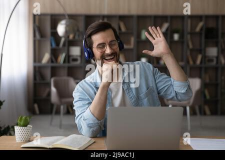 Young guy wear headset relax from computer work sing song Stock Photo